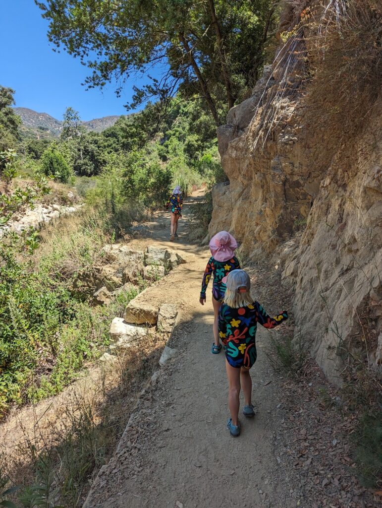 3 girls hike on a trail