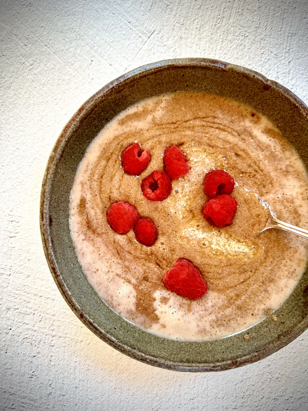 bowl of amaranth porridge topped with raspberries